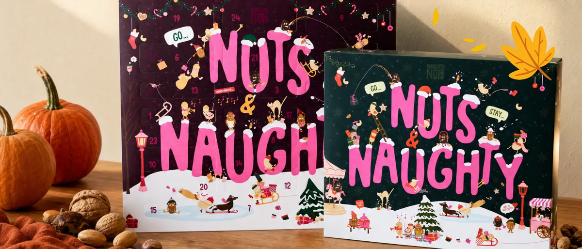 Zwei Naughty Nuts Adventskalender mit weihnachtlichen Illustrationen und Kürbissen auf einem Holztisch
